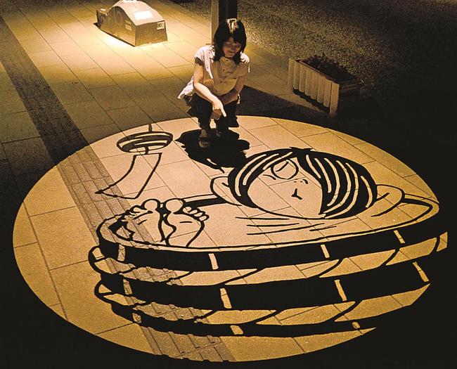 行水する鬼太郎の影絵に見入る観光客＝境港市大正町、水木しげるロード