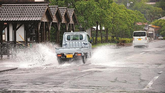 土砂降りの雨で水しぶきを上げて県道を走る車＝３０日午前１０時５３分、島根県海士町福井（画像の一部を加工しています）