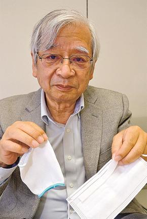 着脱テープを付けた不織布マスクと、マスクガーゼを手にする井上貴央施設長＝米子市内