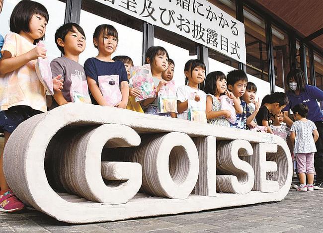 ベンチのお披露目式に花を添える園児たち＝大田市仁摩町大国、道の駅ごいせ仁摩