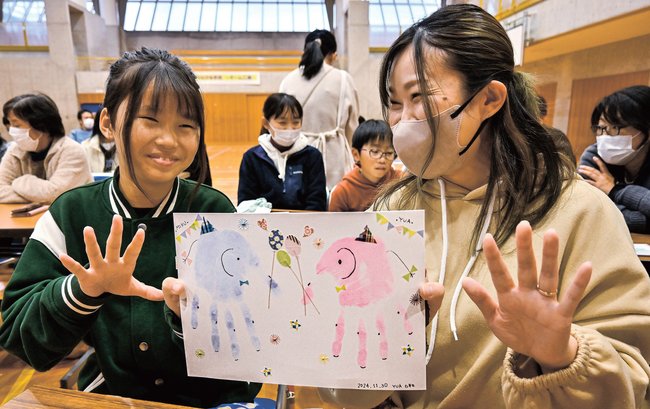 手形を使ってゾウの絵を完成させた親子＝浜田市三隅町古市場、三隅小学校