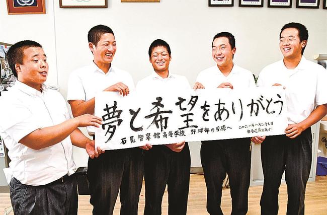 滞在したホテル周辺の住民からもらった書状を手に、笑顔を見せる野球部員＝江津市渡津町、石見智翠館高校