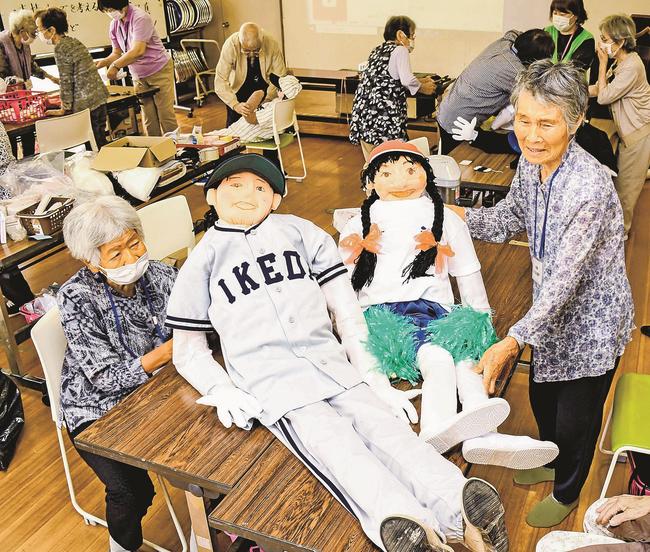 完成したかかしを見せ合う池田すこやかクラブのメンバー＝大田市三瓶町、池田まちづくりセンター