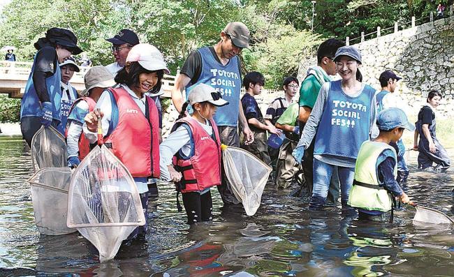 たもを持ち、生き物を探す参加者＝松江市殿町、堀川