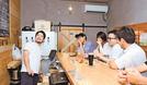 空き倉庫を活用したクラフトビール専門店で客と談笑する永川祥平さん（左）。霧島の街を一緒に盛り上げようと，週末はイベントに参加する＝鹿児島県霧島市、ＡＳＨ　ＨＥＡＤ　ＢＲＥＷＥＲＹ