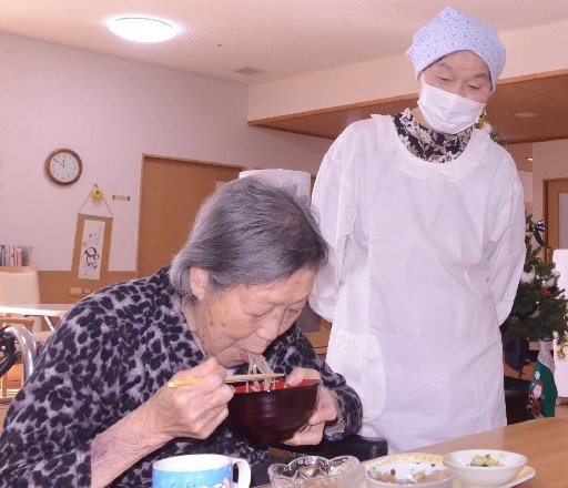 そばを味わう高齢者を見守る田中コヅエさん（右）＝大田市川合町、眺峰園