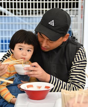 牛骨ラーメンを食べる親子=米子市末広町