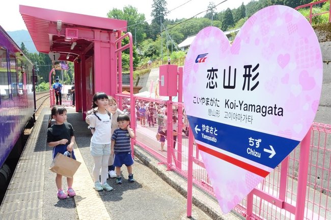 リニューアル１０周年を記念して新たに設置された駅名標を眺める親子＝鳥取県智頭町大内、恋山形駅