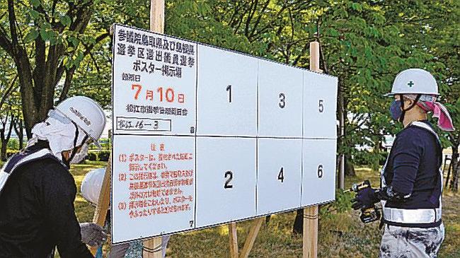ポスター掲示板を設置する委託業者＝松江市末次町、末次公園