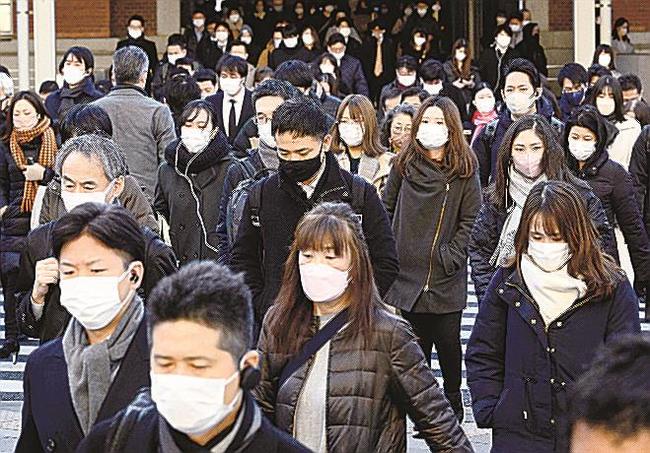 ＪＲ東京駅前で、マスク姿で通勤する人たち＝２０日午前