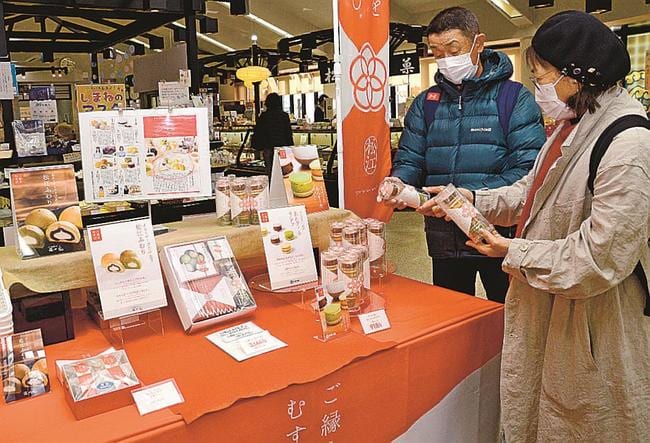 特設コーナーで、ご縁をむすびを手に取る観光客＝松江市殿町、島根県物産観光館