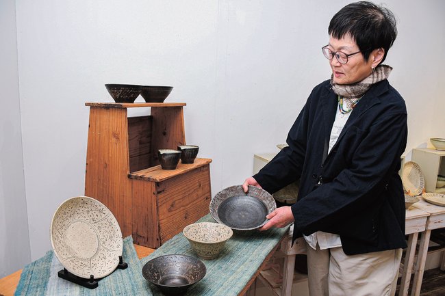 作品を手にする角りわ子さん=境港市日ノ出町、一月と六月
