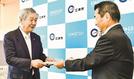山下修市長（左）に書籍の目録を手渡す大屋剛専務取締役