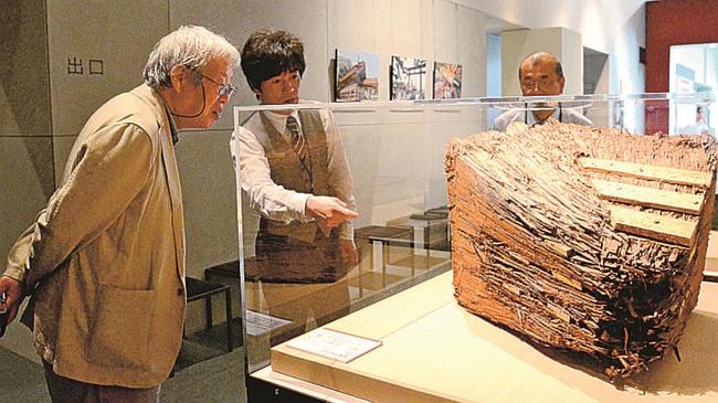 特別展「平成の大遷宮　出雲大社展」で岡宏三専門学芸員（中央）の説明を受ける立花隆さん（左）＝２０１３年５月、出雲市大社町杵築東、島根県立古代出雲歴史博物館
