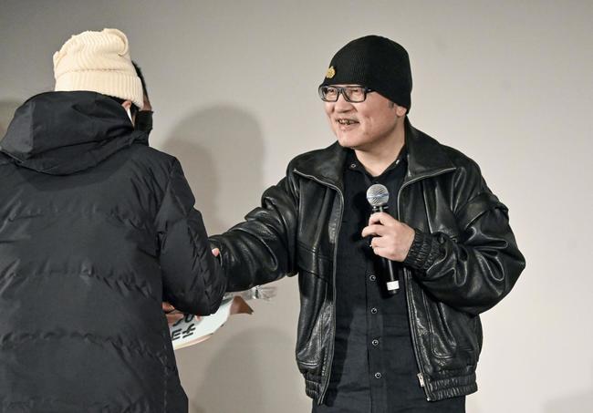 交流会でファンと握手する「名探偵コナン」の作者・青山剛昌さん＝１月３日、鳥取県北栄町