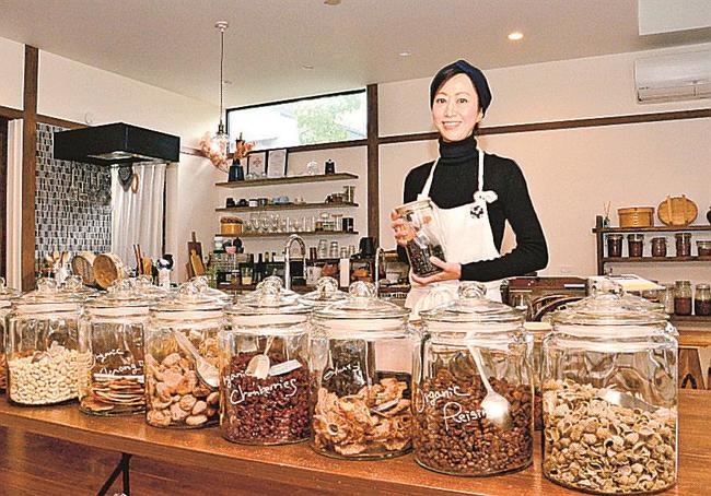 量り売り用のドライフルーツやナッツが並ぶ店内に立つ青木麻衣さん＝出雲市渡橋町