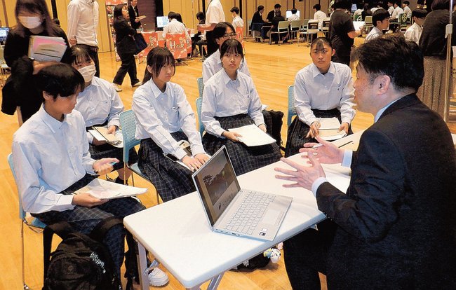 企業の担当者（右）の説明を聞く参加者＝安来市飯島町、市総合文化ホール・アルテピア