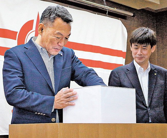 秋の大プレゼントで抽選する淋蒔歳暢社長（左）＝松江市殿町、山陰中央新報社