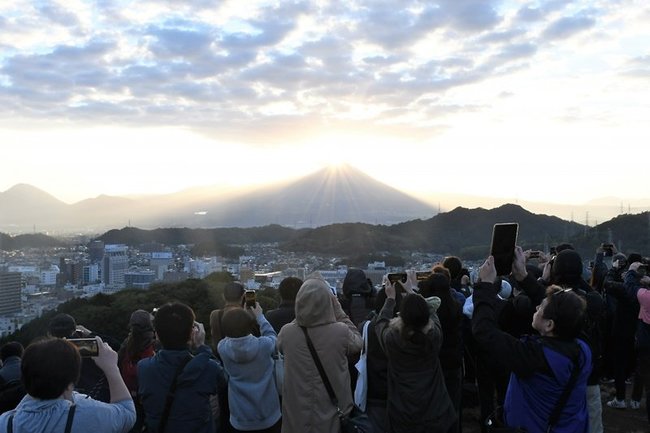 米子城跡から「ダイヤモンド大山」を写真に収める参加者＝米子市久米町