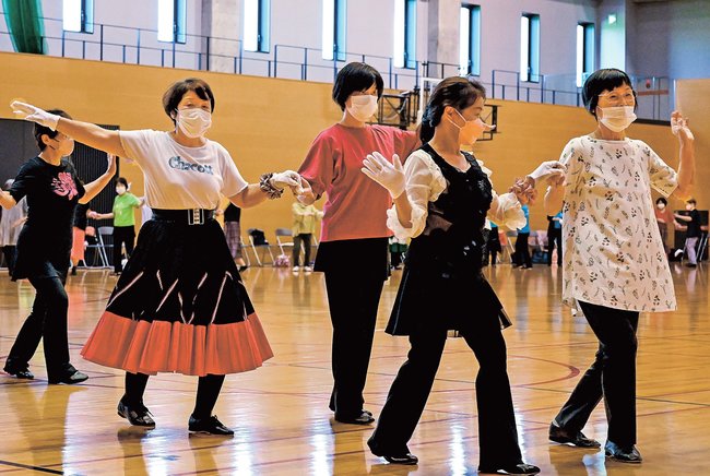 記念大会で手をつなぎ踊る参加者＝松江市学園南１丁目、市総合体育館