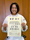 第５２回全国中学校柔道大会の賞状を手に笑顔の永田理穏さん＝米子市両三柳、鳥取県立武道館