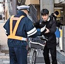 
          
自転車のヘルメット着用を呼びかけるチラシを受け取る市民（右）＝松江市朝日町、ＪＲ松江駅西駐輪場前
        