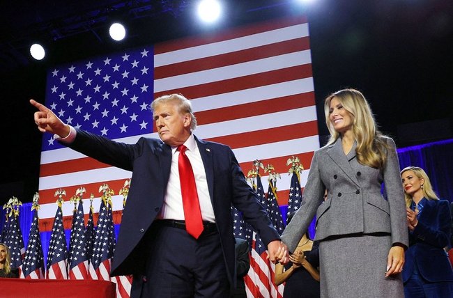 米フロリダ州の集会会場に妻のメラニアさん（右）と登場し、ポーズをとるトランプ前大統領。大統領選で勝利宣言した＝６日（ロイター＝共同）