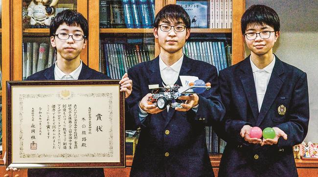 賞状とロボットを手にする（左から）大東中学校３年の澤和楓音さん、山根湊太さん、松本航希さん＝雲南市大東町養賀、市立大東中学校