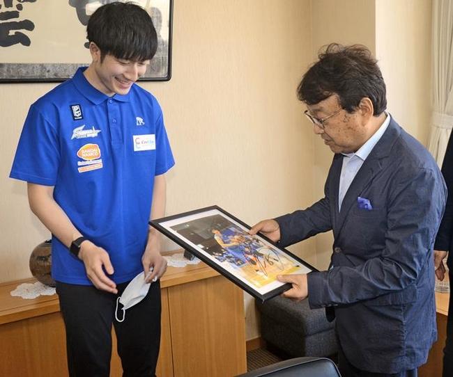 松尾倫男社長に自身のサインが入った写真について説明する白濱僚祐選手（左）＝山陰中央新報社