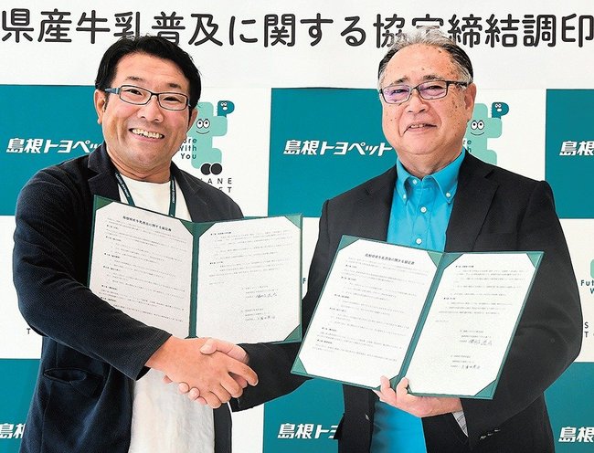 握手を交わす勝部道成社長（左）と久保田英治会長＝出雲市渡橋町、島根トヨペット出雲店