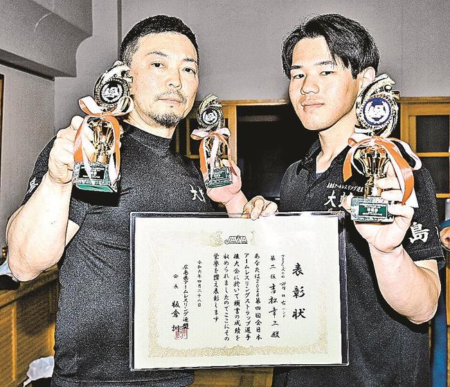 表彰状とトロフィーを手にする吉松幸二さん（左）と両手にトロフィーを持つ岡田悠さん＝益田市中吉田町、吉田小学校