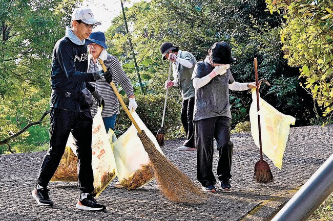 神社の境内で落ち葉を掃き集める参加者＝益田市高津町