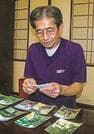 妻・泰子さんとの思い出の写真をみる荒川勉さん＝米子市祇園町２丁目