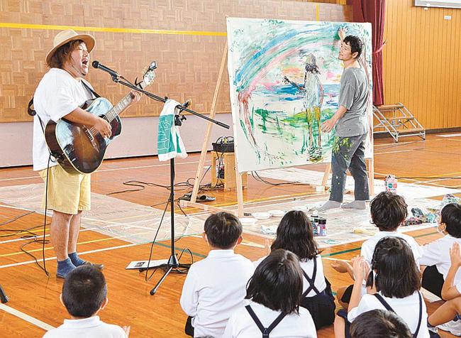歌に合わせて絵を描く近藤康平さん（右奥）＝松江市朝酌町、朝酌小学校
