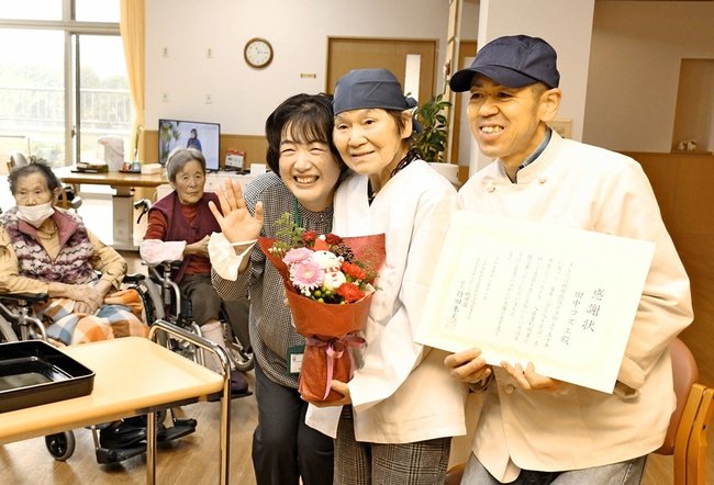 討ち入りそばを５０年間提供し、感謝状と花束を受け取る田中コヅエさん（手前中央）と伸哉さん（右）＝大田市川合町、眺峰園