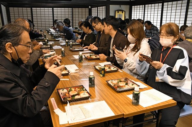 江戸後期の祝い膳を再現した弁当を撮影する参加者＝島根県隠岐の島町下西、億岐家住宅