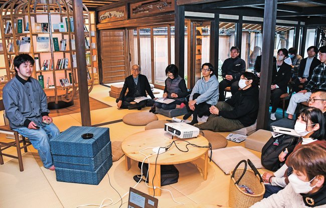 間歩を利用したサツマイモの熟成研究を発表する下柳田聡さん（左）＝大田市大森町、石見銀山まちを楽しくするライブラリー