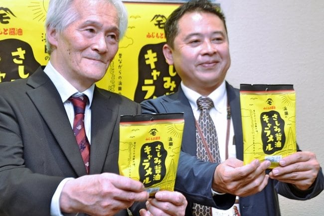 商品を手にするふじもと醤油の藤本太郎社長（左）と浜田市観光協会の中山良一事務局長＝浜田市内