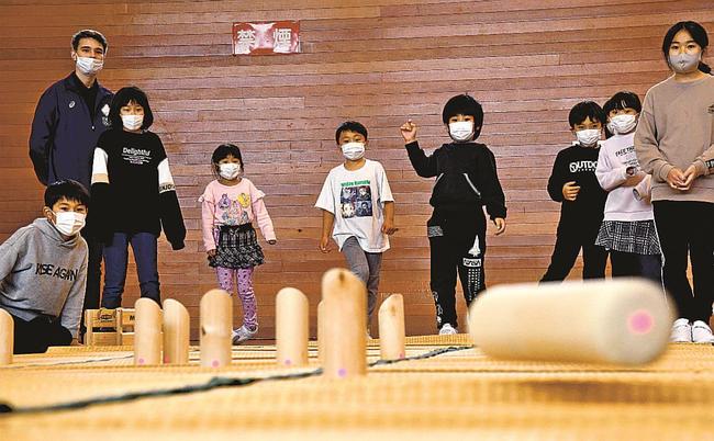 サカリさん（左から２人目）とモルックを楽しむ児童＝島根県邑南町井原、井原公民館