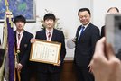 丸山知事と記念撮影に納まる小野主将（左）と黒田選手（左から２人目）