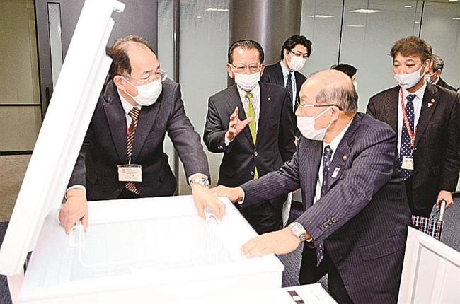 超低温冷凍庫を確認する上田広美社長（左から２人目）と長岡秀人市長（同４人目）