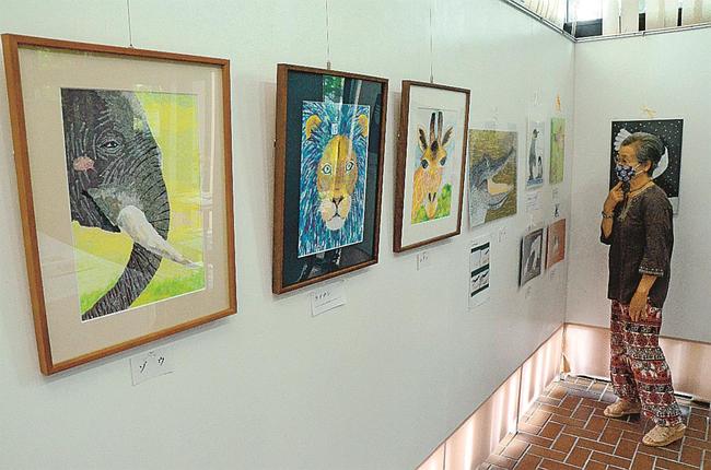 マスキングテープで表現した動物たちの作品に見入る来場者＝松江市玉湯町玉造、出雲玉作資料館