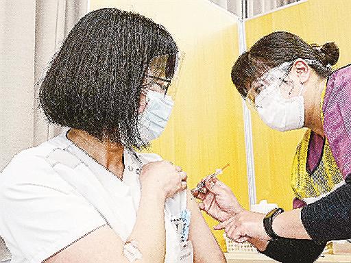 国立病院機構の函館病院で、新型コロナウイルスワクチンの３回目の追加接種を受ける看護師（左）＝１日、北海道函館市