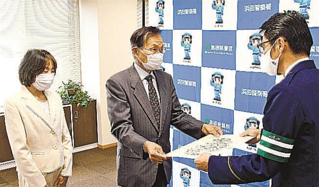 佐々木肇署長（右）から感謝状を受け取る盆子原温さん、美穂子さん夫婦＝浜田市黒川町、浜田署