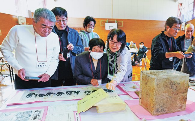 タイムカプセルの中身を確認する当時の在校生ら=島根県美郷町都賀行、旧〓(都の日の右上に「、」)賀行小学校体育館