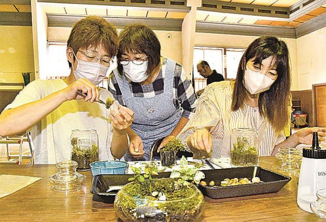 地元住民（中央）の手ほどきを受け、コケを使った観賞用テラリウム作りに挑戦する参加者＝江津市跡市町、旧跡市小学校