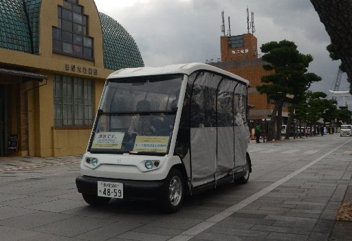観光客を乗せて神門通りを走るゴルフカート型電動カー＝出雲市大社町杵築南