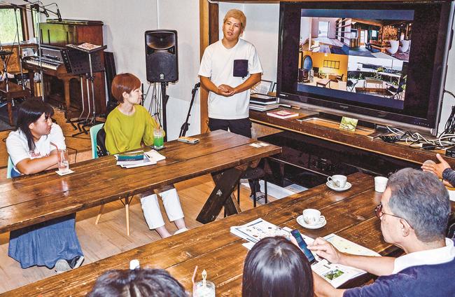大阪市から浜田市に移住した浅見治輝さん（中央奥）の生活の話を聞くツアー参加者＝浜田市下府町、ｈａｍａｉｒｏ