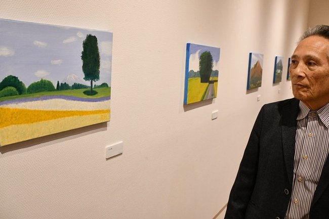 「花回廊」（左）など明るい油彩画を描く秦野良二さん＝鳥取市丸山町、ギャラリー３３０