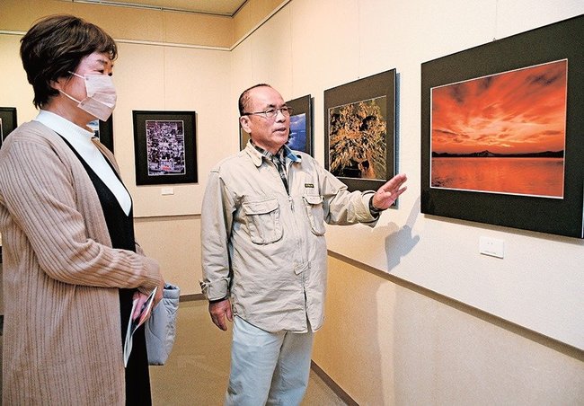 来館者に作品を解説する門脇正八さん（右）＝境港市花町、海とくらしの史料館